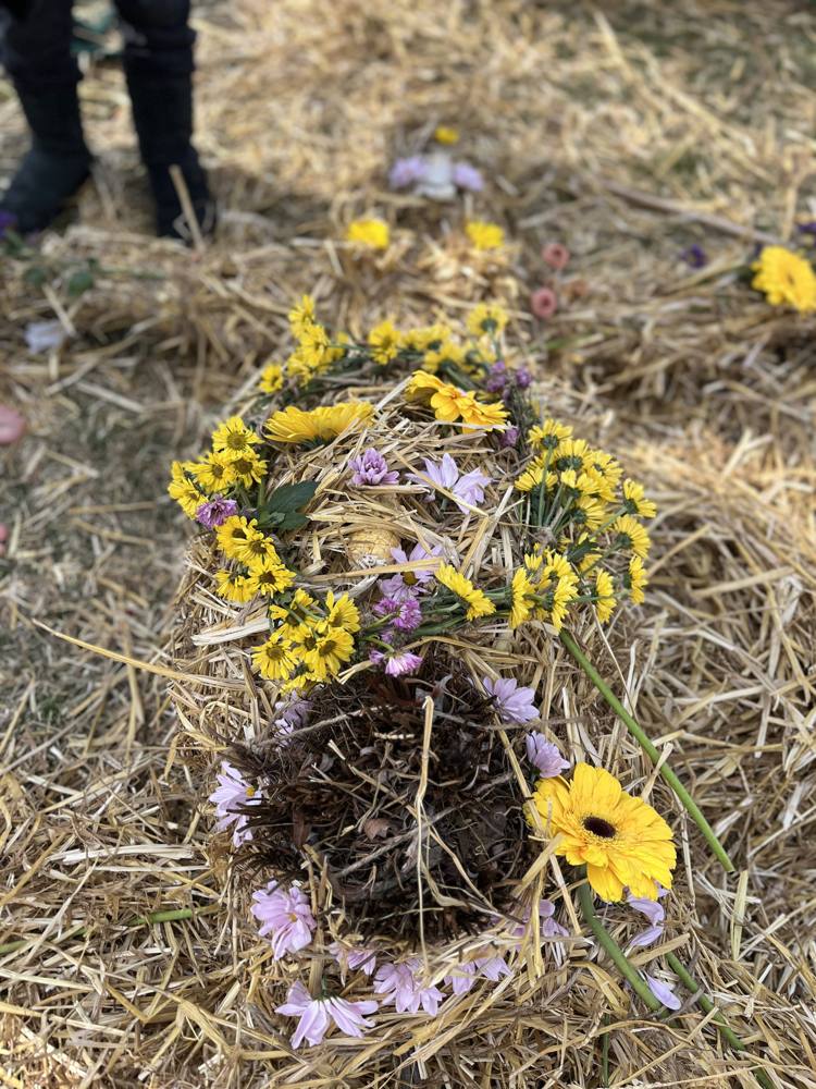 The straw effigy dressed with yellow and pink flowers